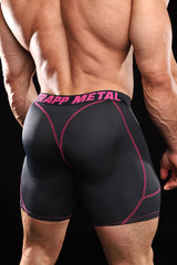 Rear view of a muscular man wearing black compression shorts with pink stitching and a pink and black waistband that reads 'STRAPP METAL'.